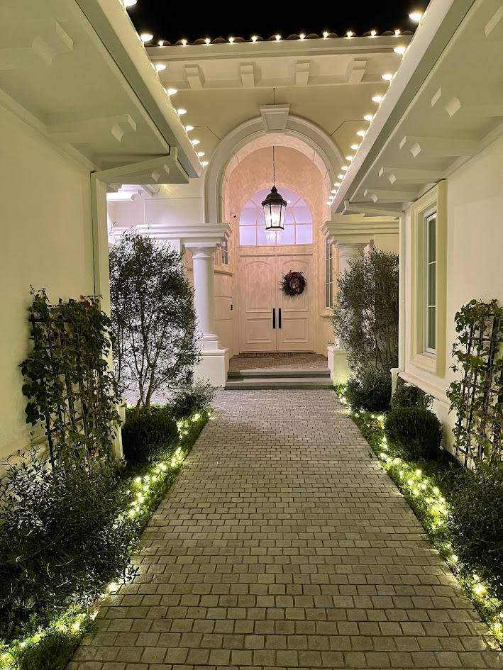 Warm white holiday lighting on bushes in Encino